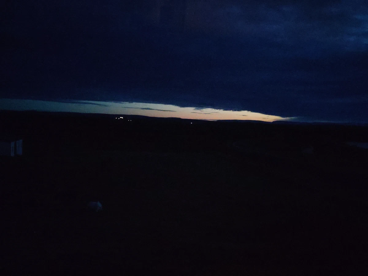 Fast dunkle Landschaft kurz nach Mitternacht, am Horizont ein heller Streifen Dämmerlicht