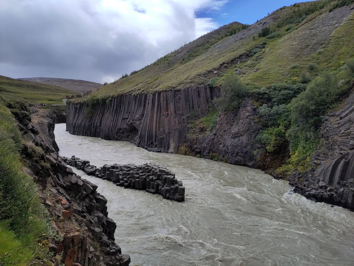 Blick in die Schlucht mit Basaltsäulen an beiden Ufern und einer Felsinsel im Fluss