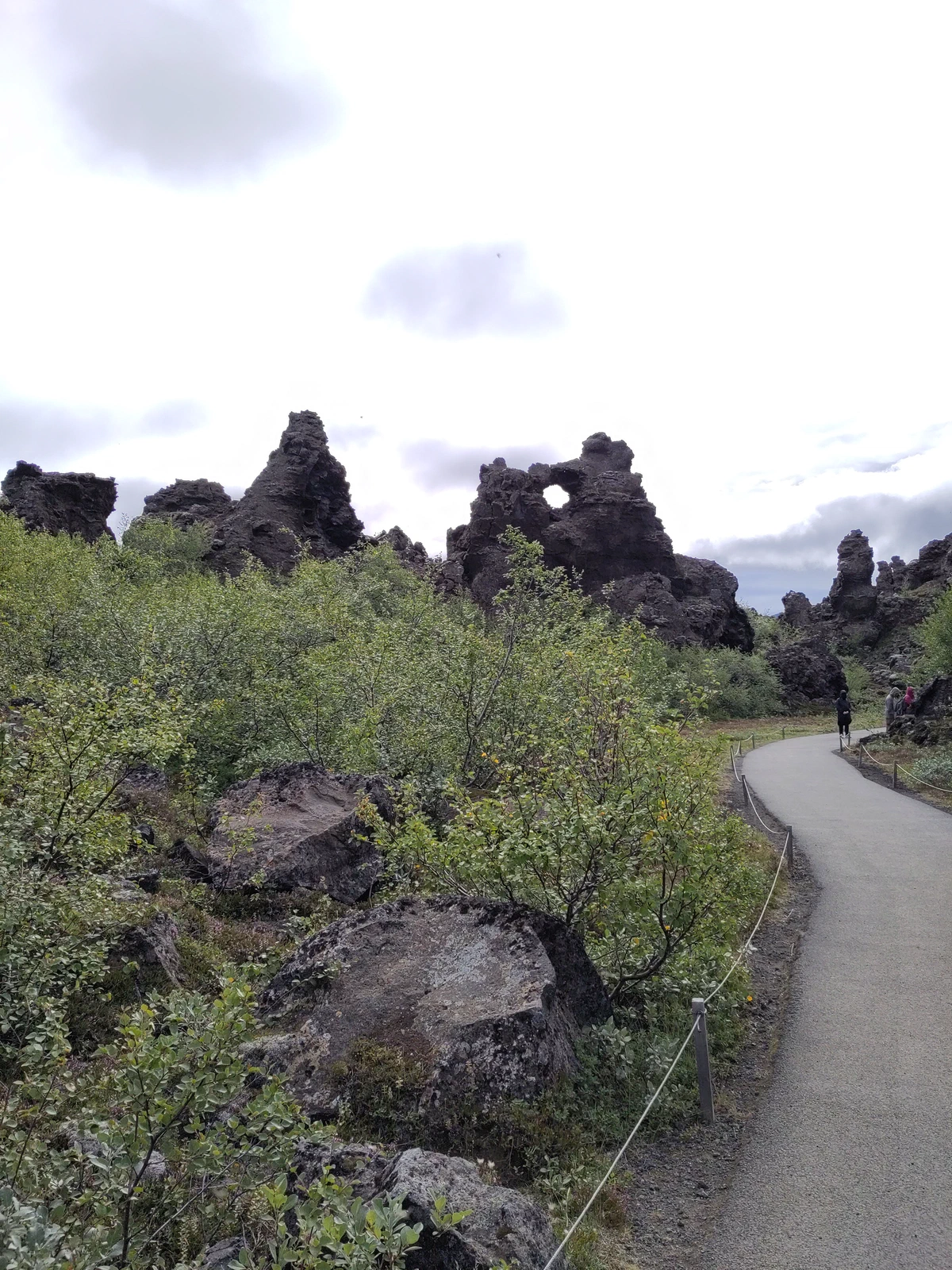 Weg durch das Lavafeld Dimmuborgir, vorbei an dunklen, bizarr geformten Lavatürmen