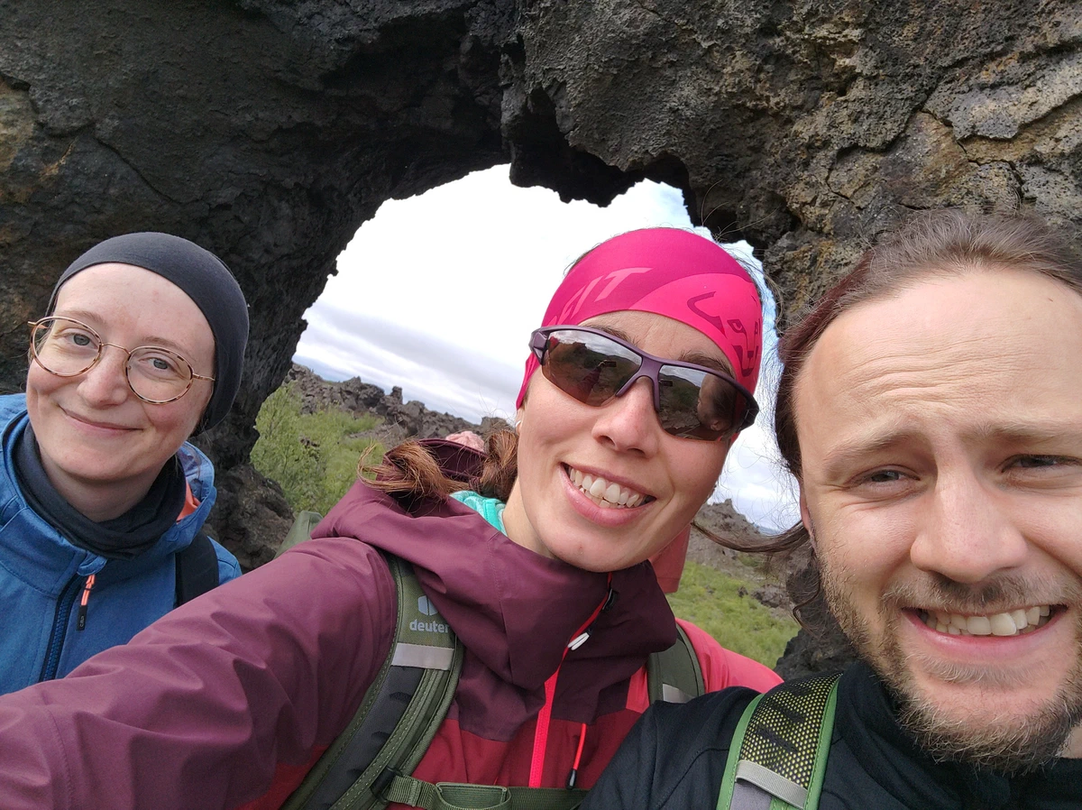 Selfie zu dritt vor einem Felsentor aus Lava