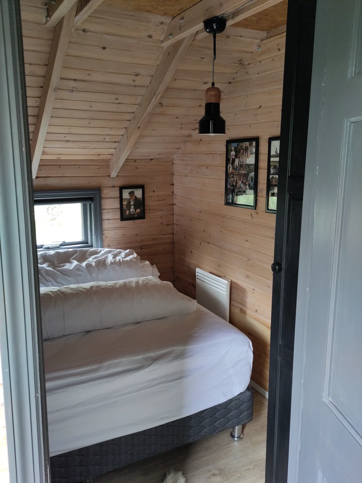 Blick durch die Tür ins Schlafzimmer mit holzverkleideten Wänden