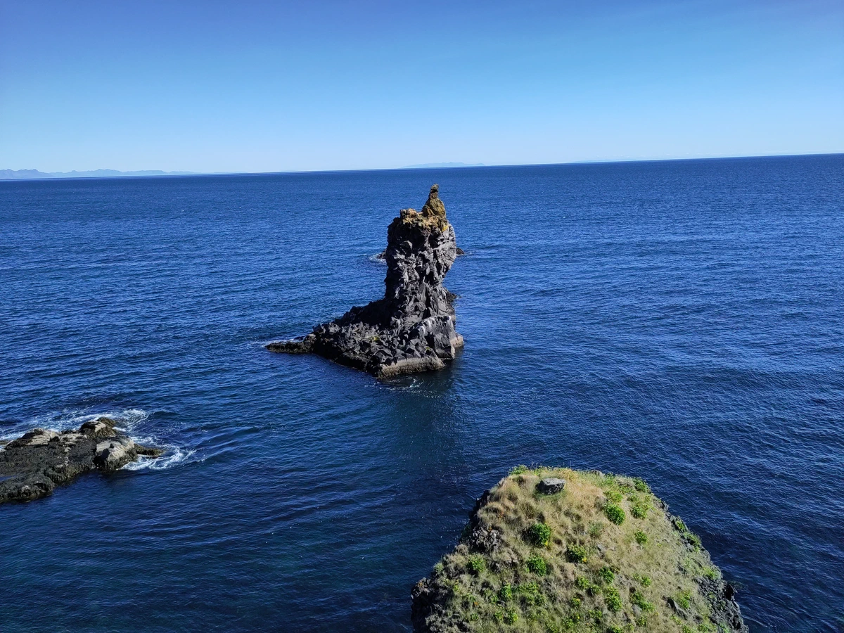 Einzelne Felsnadel ragt aus dem tiefblauen Meer