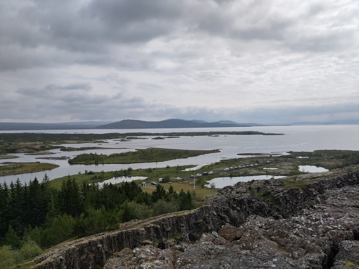 Blick über die Felsspalte auf die Seenlandschaft von Þingvellir mit kleinen Inseln