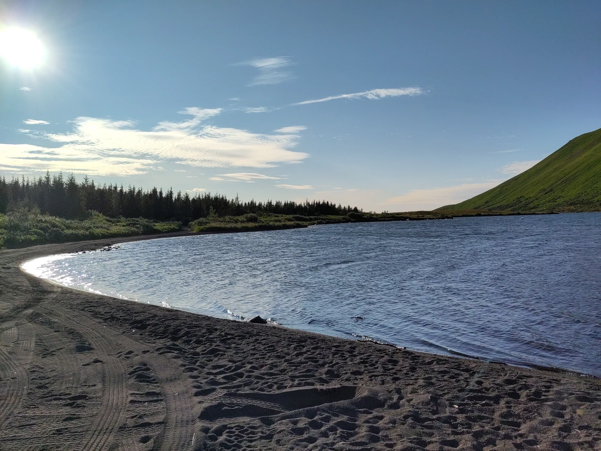 Dunkler Sandstrand am See im Abendlicht
