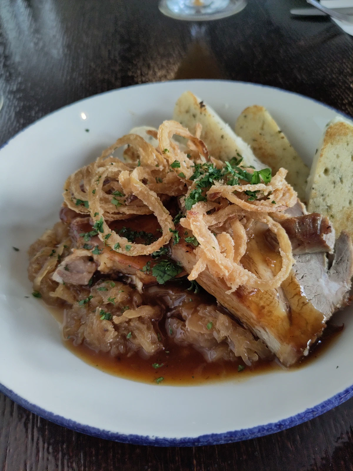 Braten mit Röstzwiebeln und Knödeln auf einem Teller