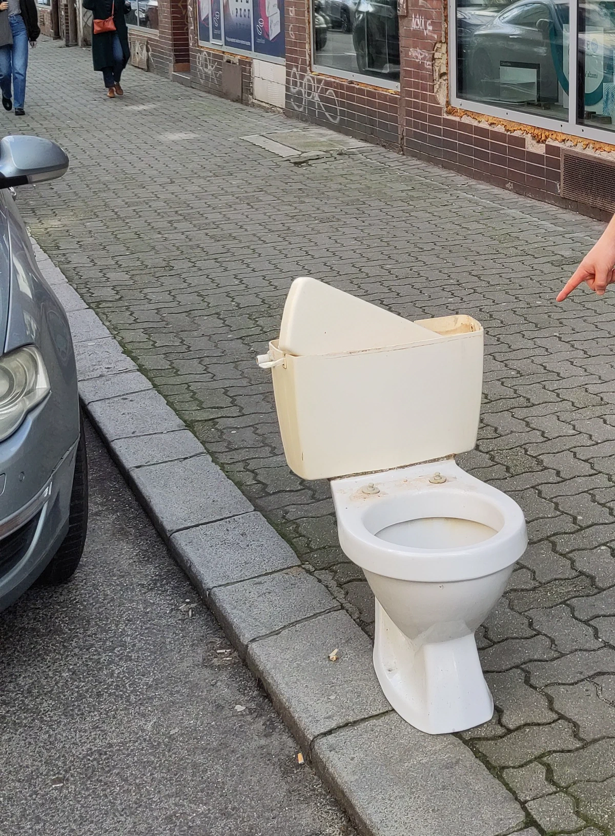 Eine ausrangierte Kloschüssel steht mitten auf dem Gehsteig