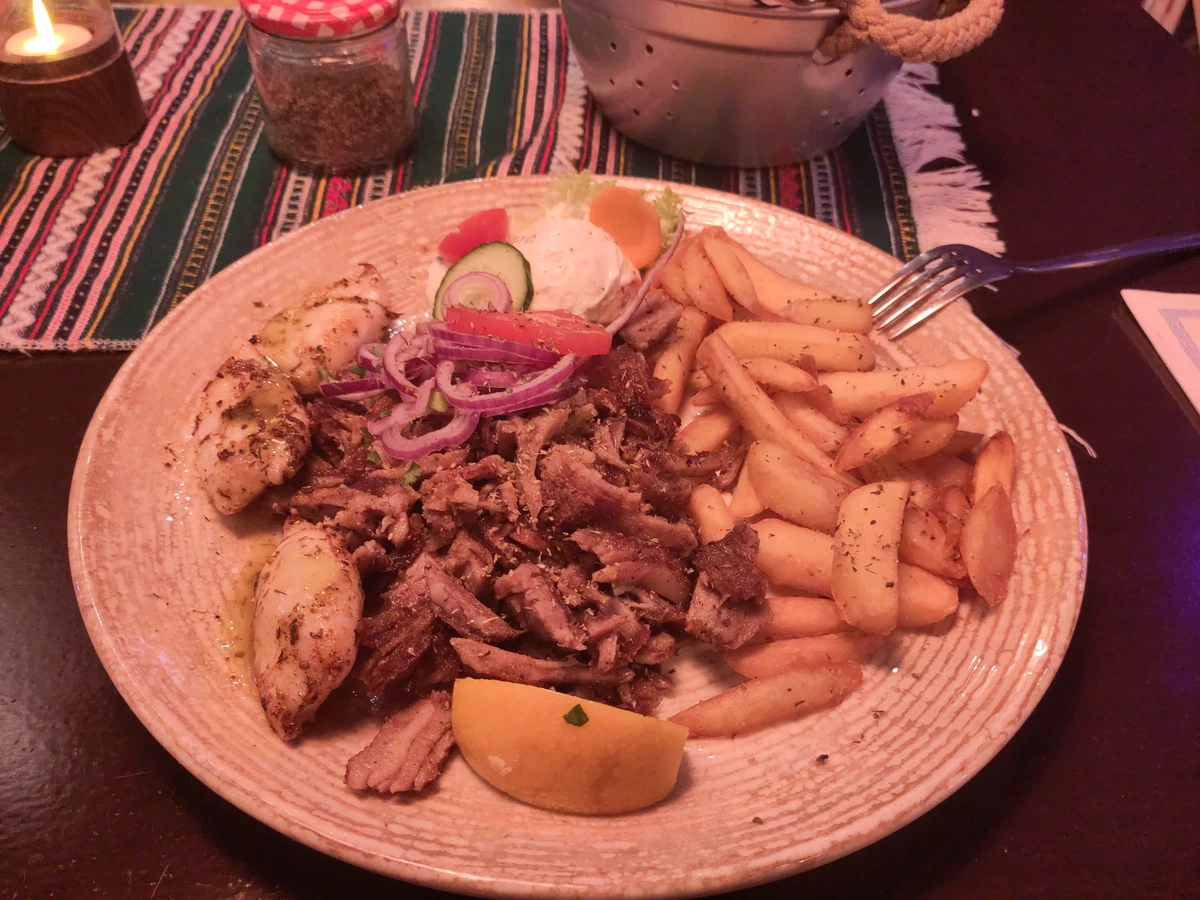 Gyros mit Pommes, Zwiebeln und Zitrone auf einem Teller