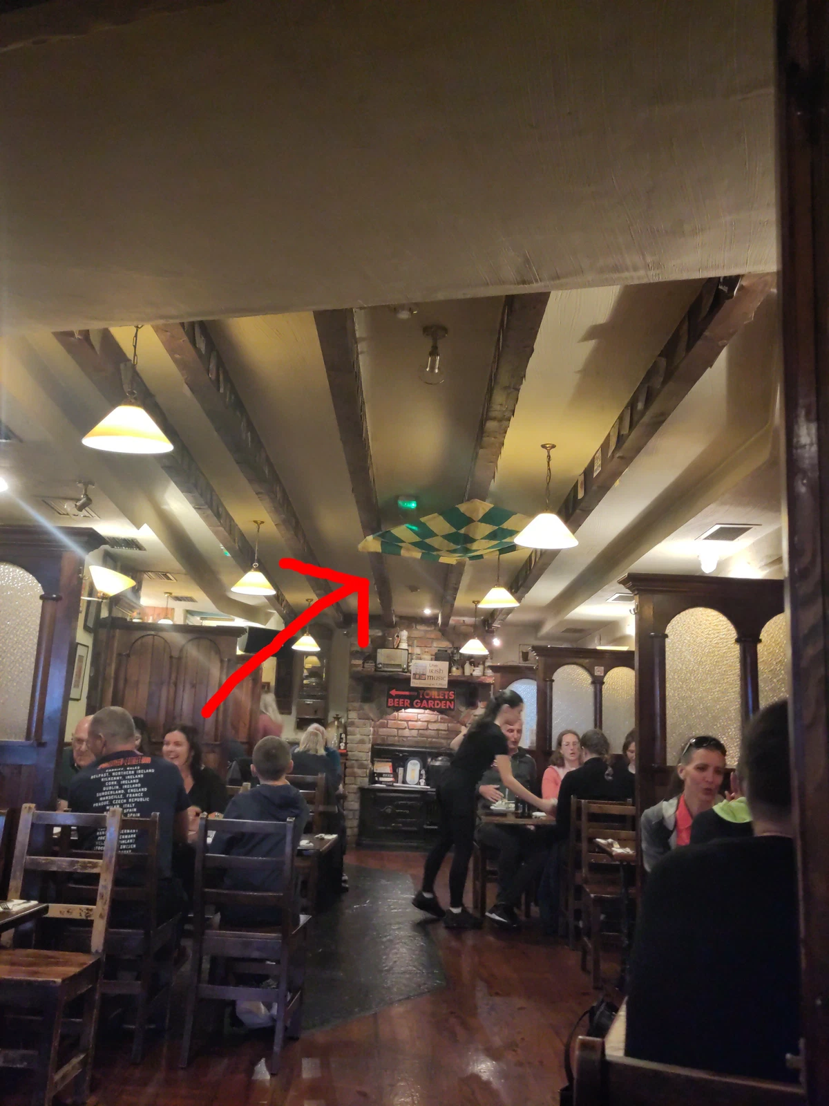 Pub von innen, ein roter Pfeil zeigt auf eine bayerische Fahne an der Decke