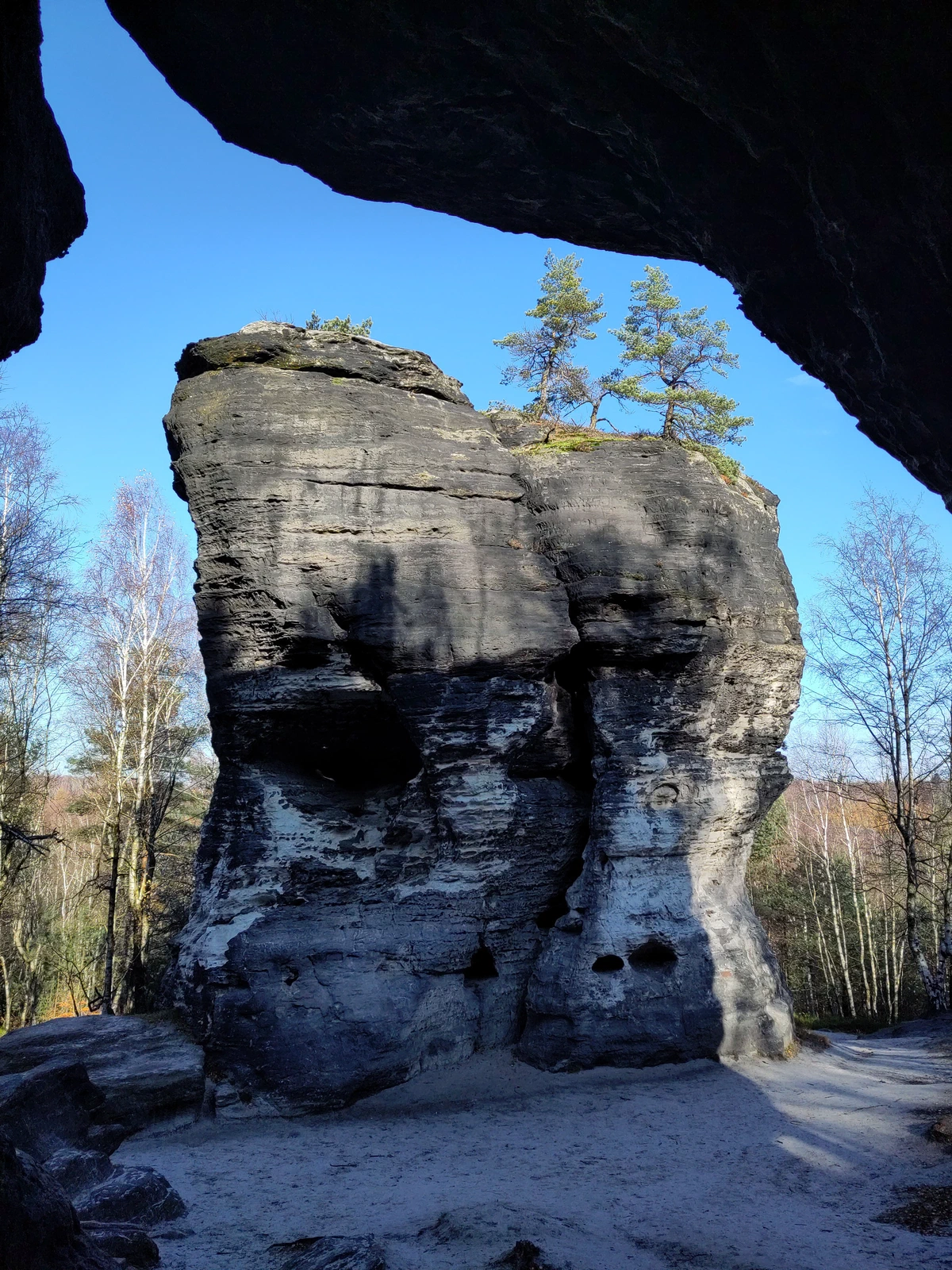 Frei stehender Sandsteinturm, durch eine Felsöffnung gesehen