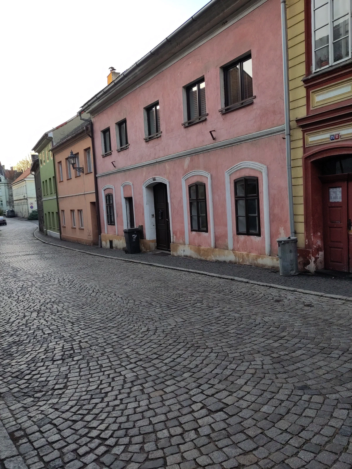 Rosa Bürgerhaus an einer gepflasterten Gasse
