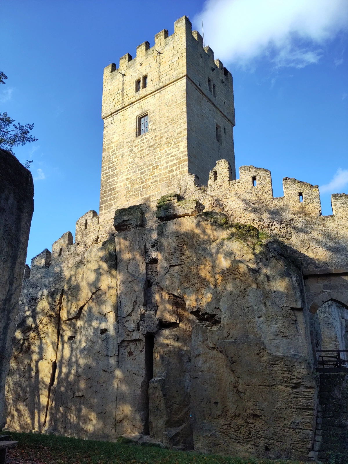 Burgturm mit Zinnen auf einem Sandsteinfelsen