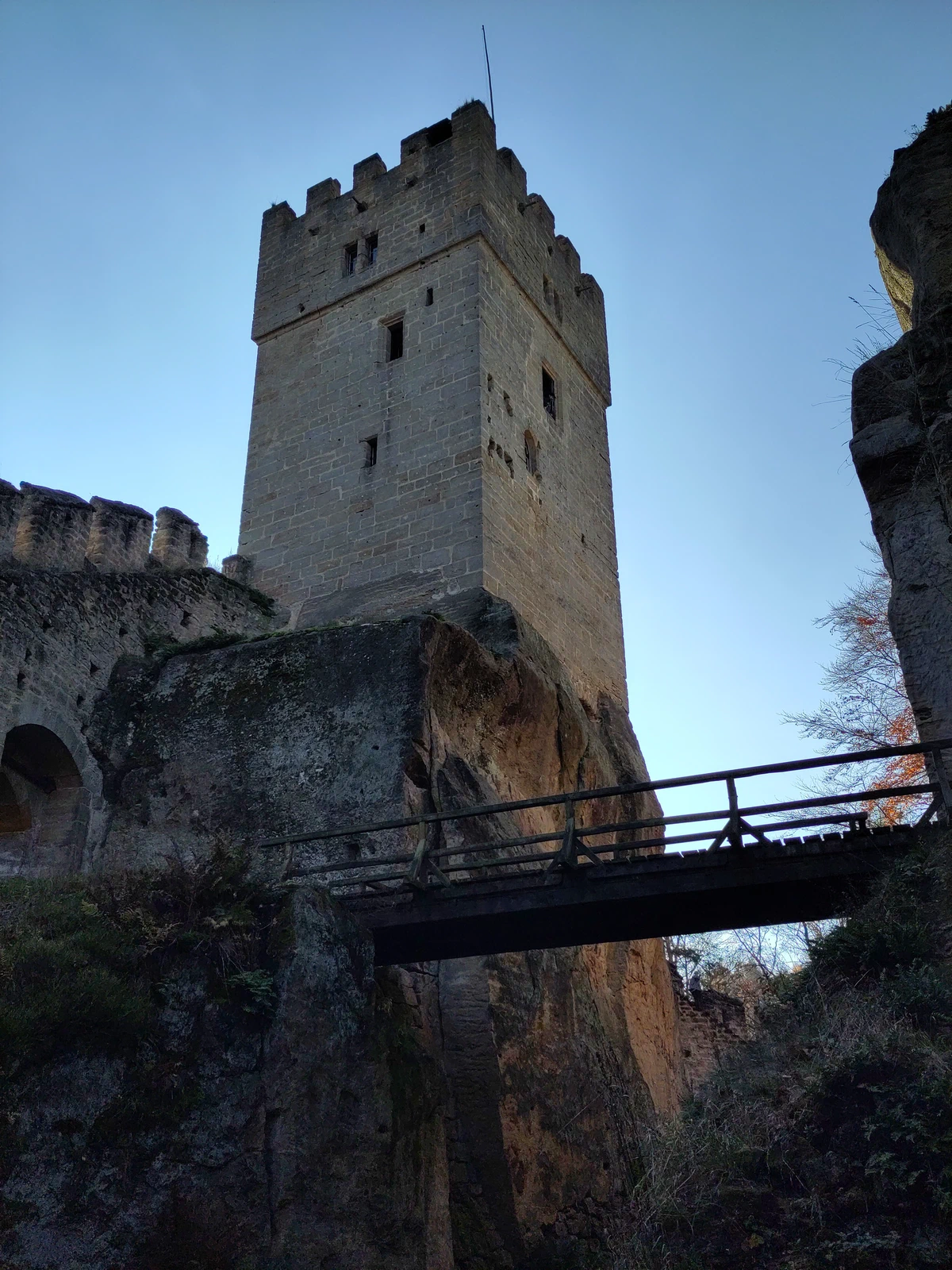 Burgturm über einer Holzbrücke, von unten gesehen
