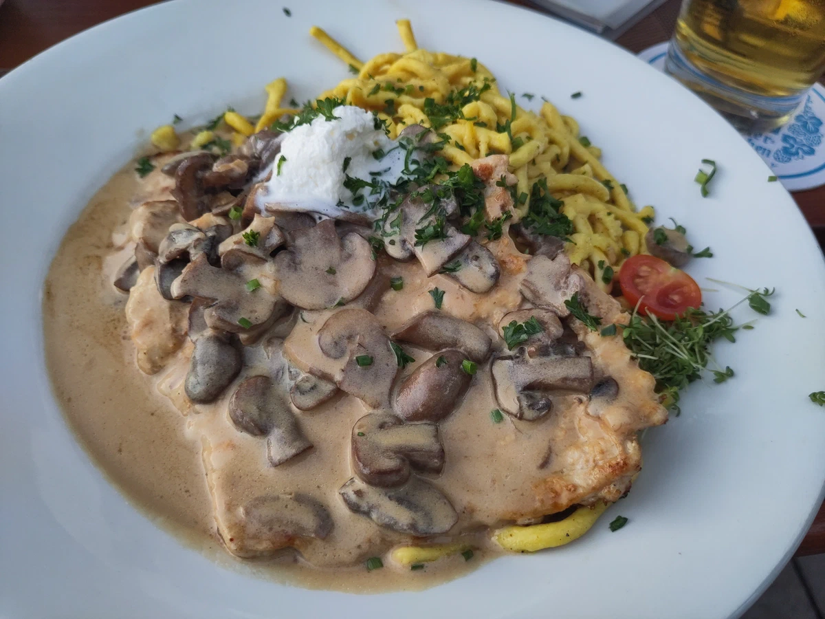 Schnitzel mit Rahmschwammerl und Spätzle auf einem großen Teller