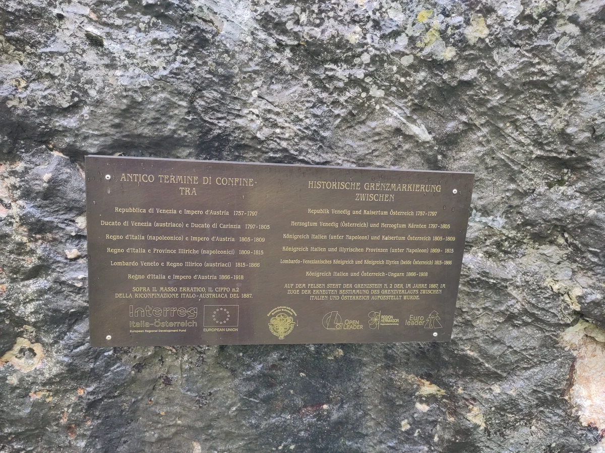 Bronzetafel am Fels zur historischen Grenzmarkierung, auf Italienisch und Deutsch