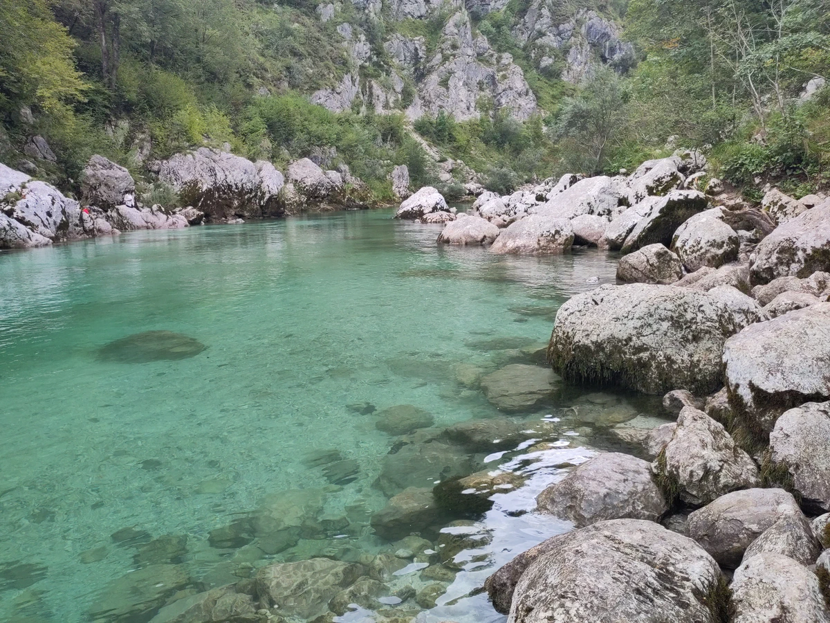 Glasklares, türkisgrünes Wasser der Soča zwischen hellen Felsblöcken