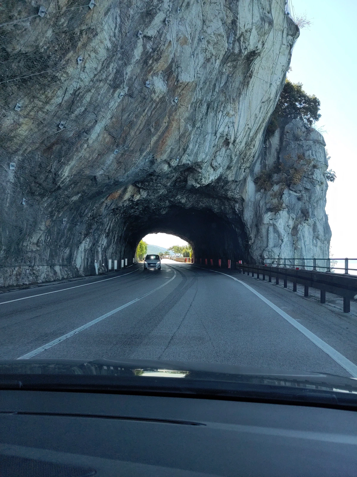 Küstenstraße führt durch einen Felstunnel, aus dem Auto fotografiert
