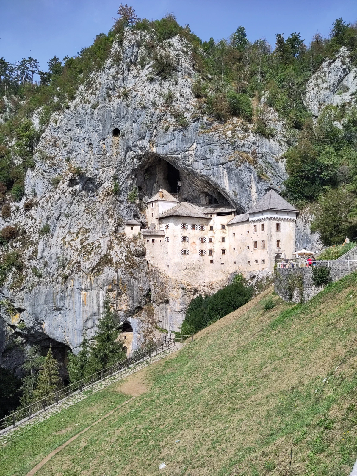 Burg Predjama: die weiße Höhlenburg klebt mitten in einer hohen Felswand