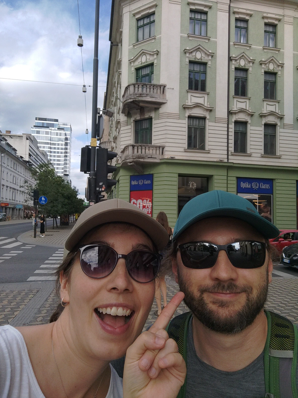 Selfie von uns beiden mit Sonnenbrillen in der Stadt, sie macht das Peace-Zeichen