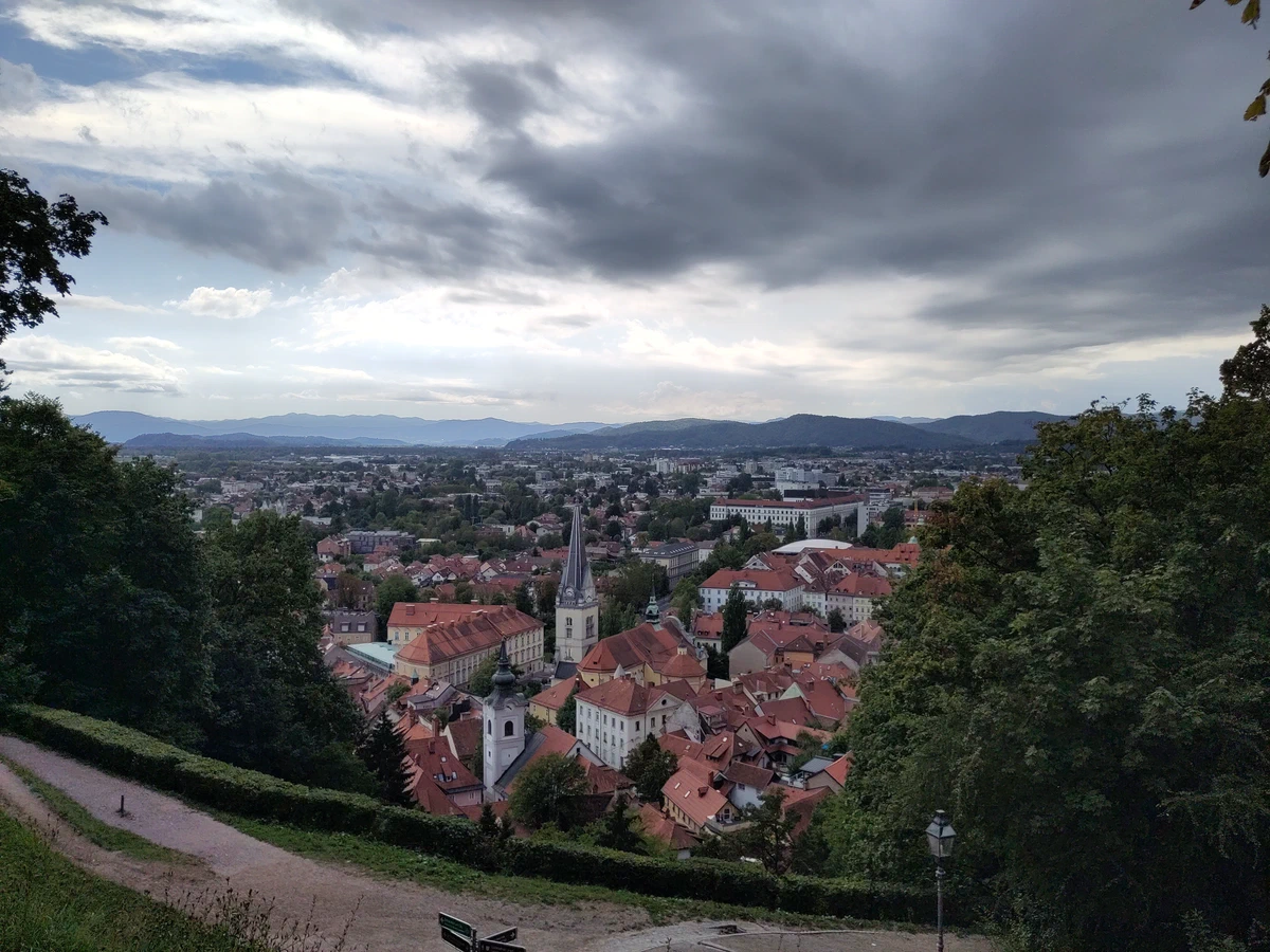 Blick vom Burghügel über die Dächer von Ljubljana unter dunklen Wolken