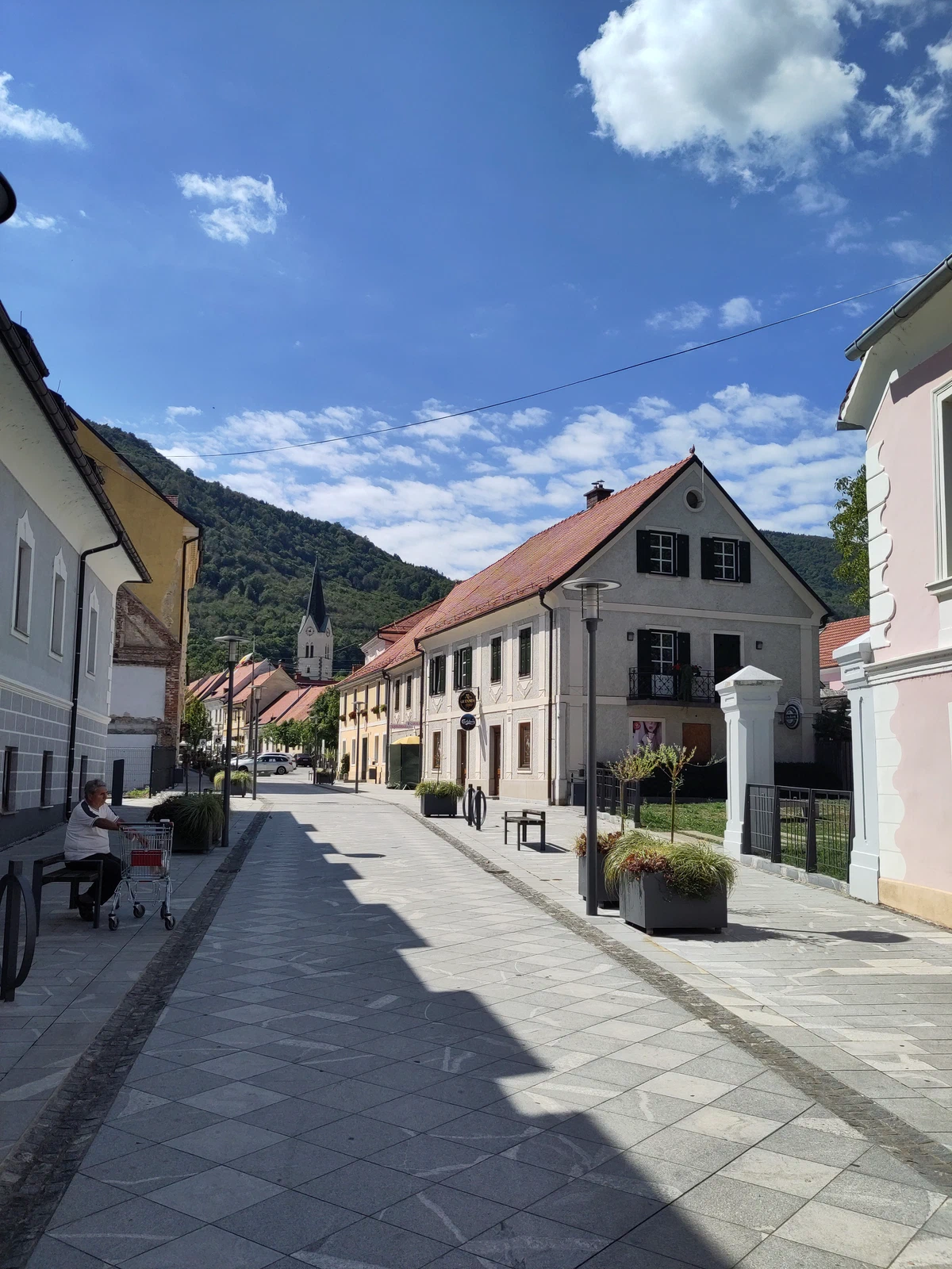 Dorfstraße mit hellen Häusern unter blauem Himmel