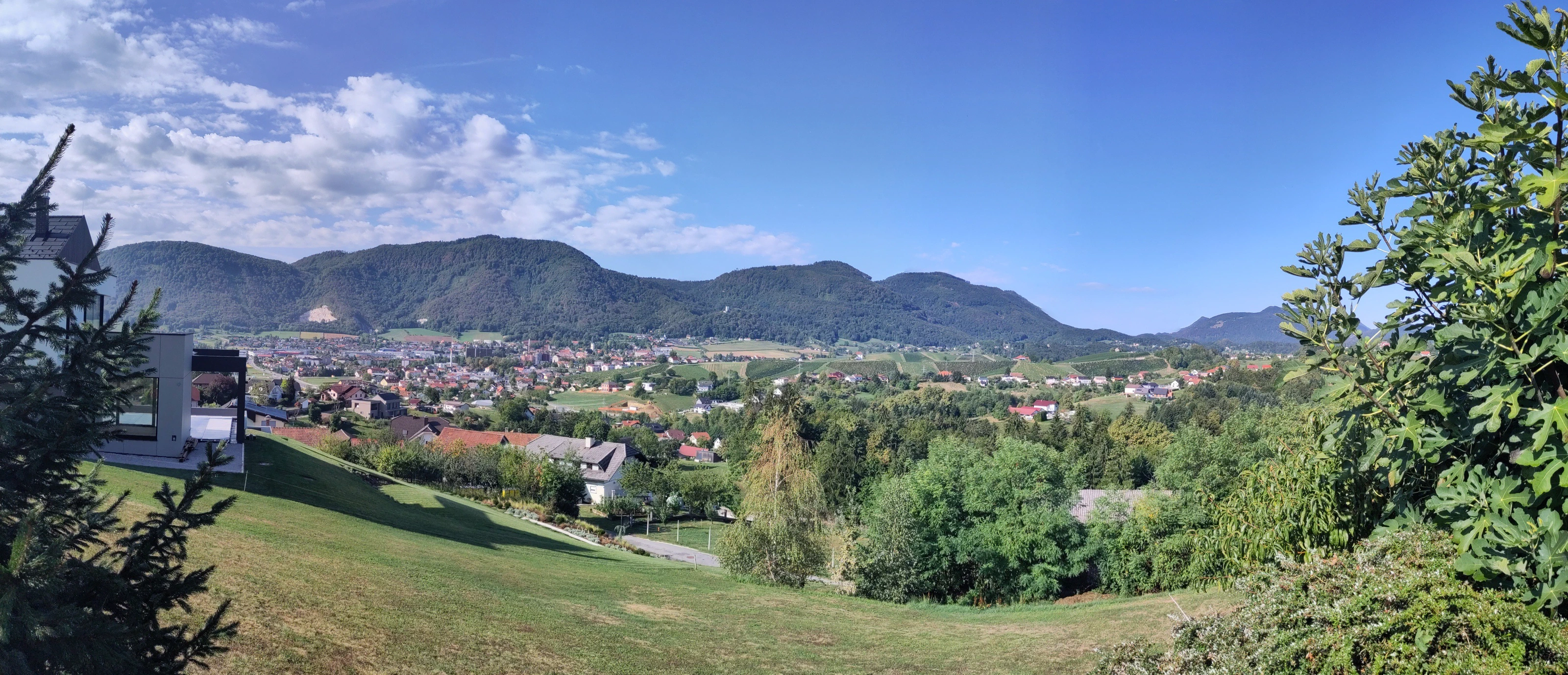 Panorama über ein grünes Tal mit Dörfern und bewaldeten Hügeln